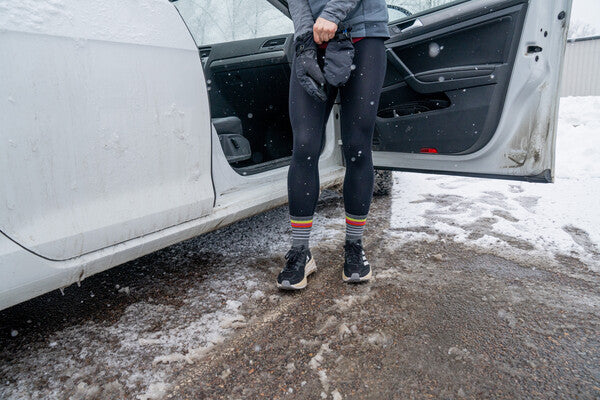 Person at their car pulling on gloves