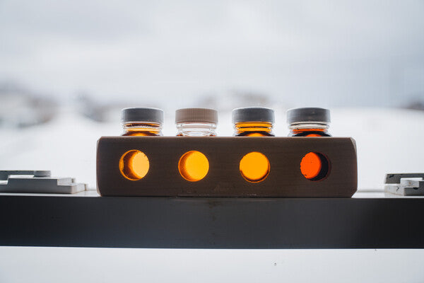 Tiny jars of maple syrup against a snowy backdrop