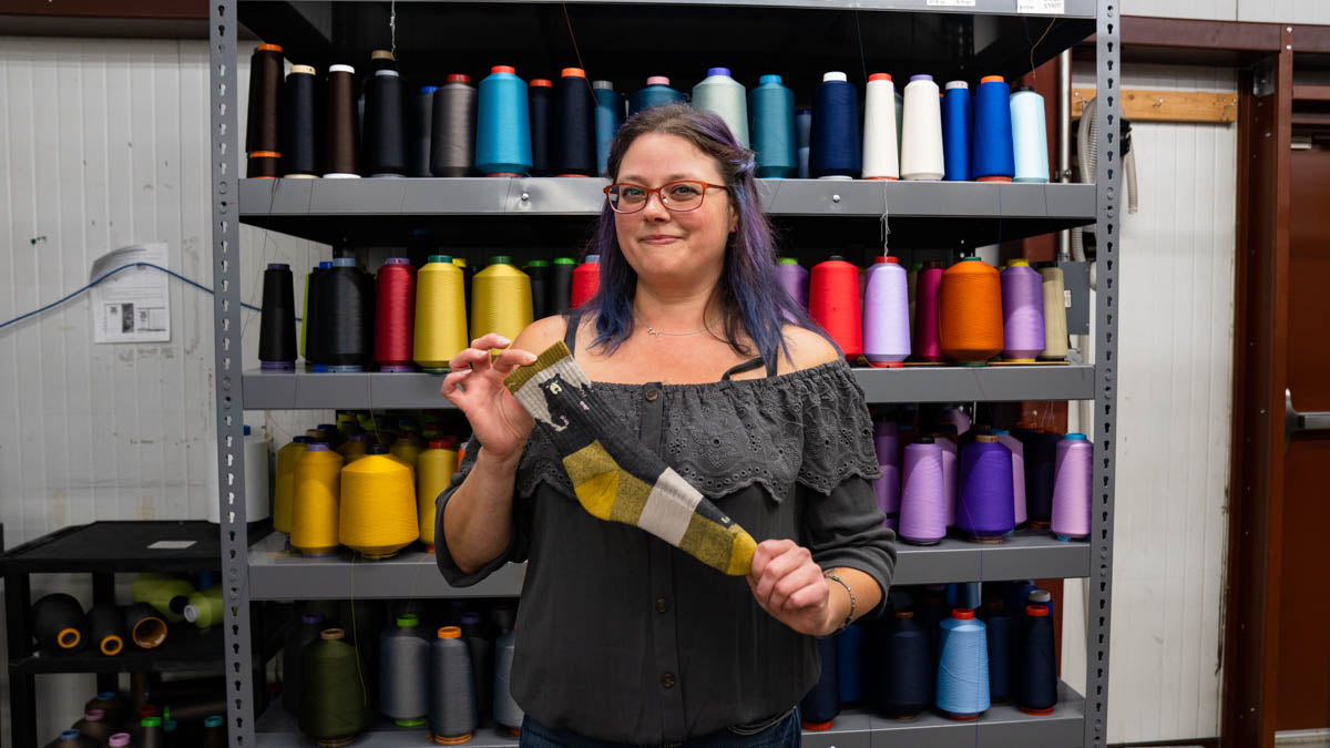 A darn tough employee holding the Bear Town sock, her go-to Christmas gift idea