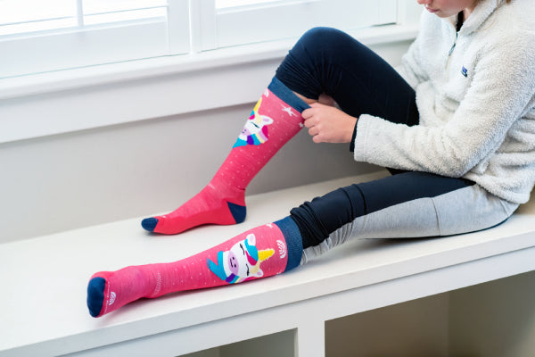 Person sitting down in Darn Tough unicorn socks