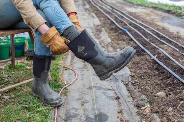 Gardener wearing Darn Tough socks and Vermont Gloves