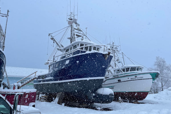 A Salmon Sister fishing boat at dry dock with snow falling all around it