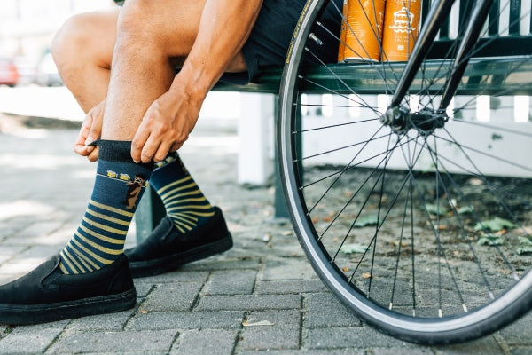 Person pulling up Darn Tough socks before a bike ride.