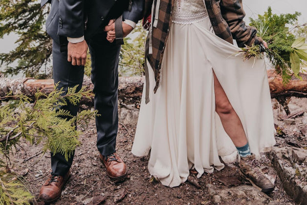 A couple out hiking in their wedding clothes and Darn Tough socks