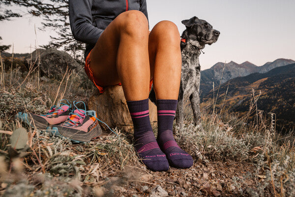 A runner with her dog, taking a break with her shoes off wearing the element micro crew, a great socks for winter runs
