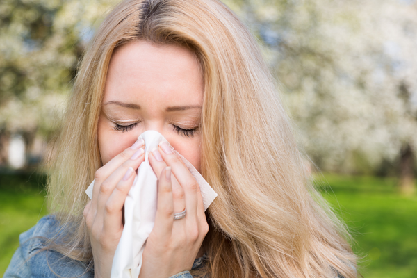 Woman using handkerchief to blow her nose