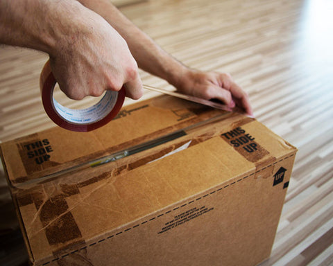 Man Packing a Moving Box with Brown Tape