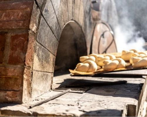 Bread being cooked in a pizza oven