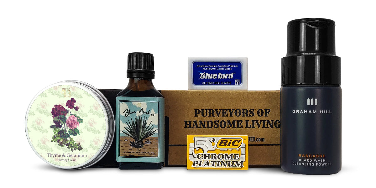 July/August '22 shaving subscription renewal kit featuring shaving cream, pre-shave oil, face wash, and double-edge blades on a white background