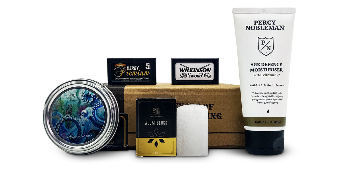 Complete Discovery Shaving Box on white background featuring aqua shaving soap, alum block, age defence moisturiser, and 2 packs of de razorblades