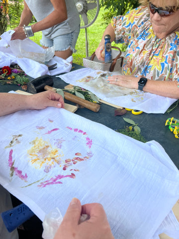 women pounding flowers into towel