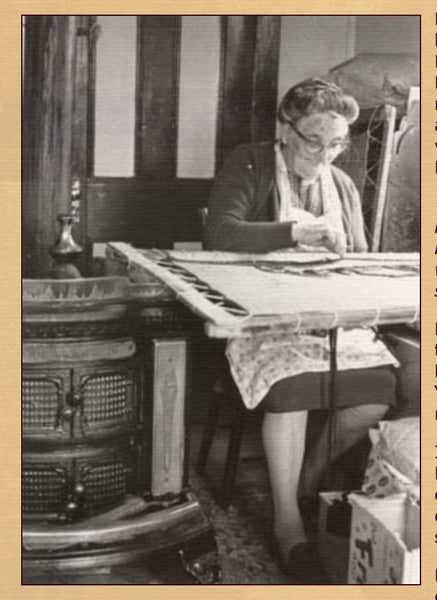 Louise Belbin hooking by her stove in her shop connected to her home.