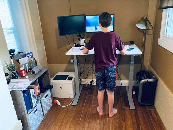 Child standing at standing desk 