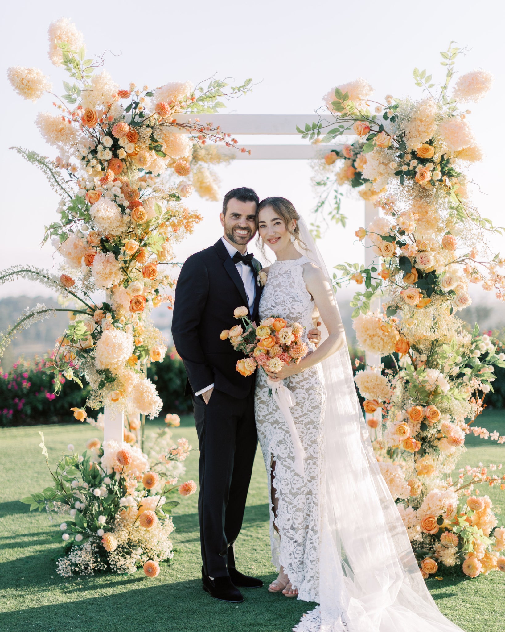 Four-tiered floral chuppah in shades of peach and yellow.