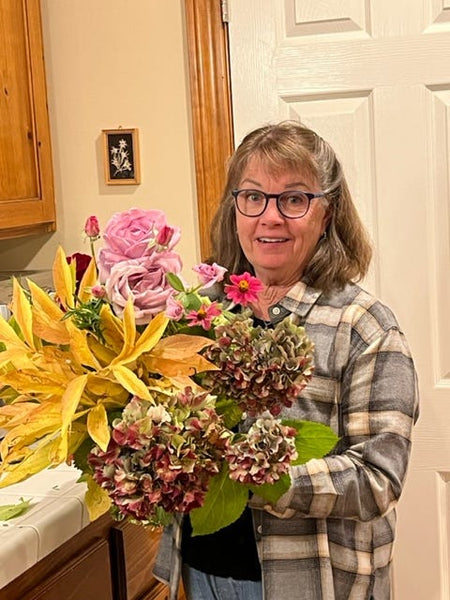 Woman holding fresh flower arrangement in a vase