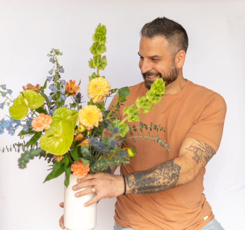 Man wearing t-shirt receives colorful flower arrangement