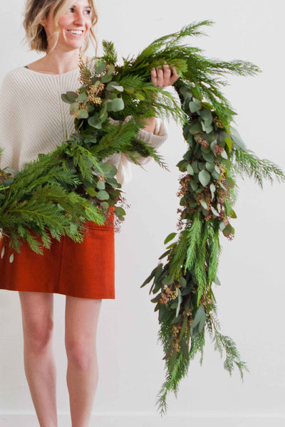 Natalie Gill holds holiday greenery garland