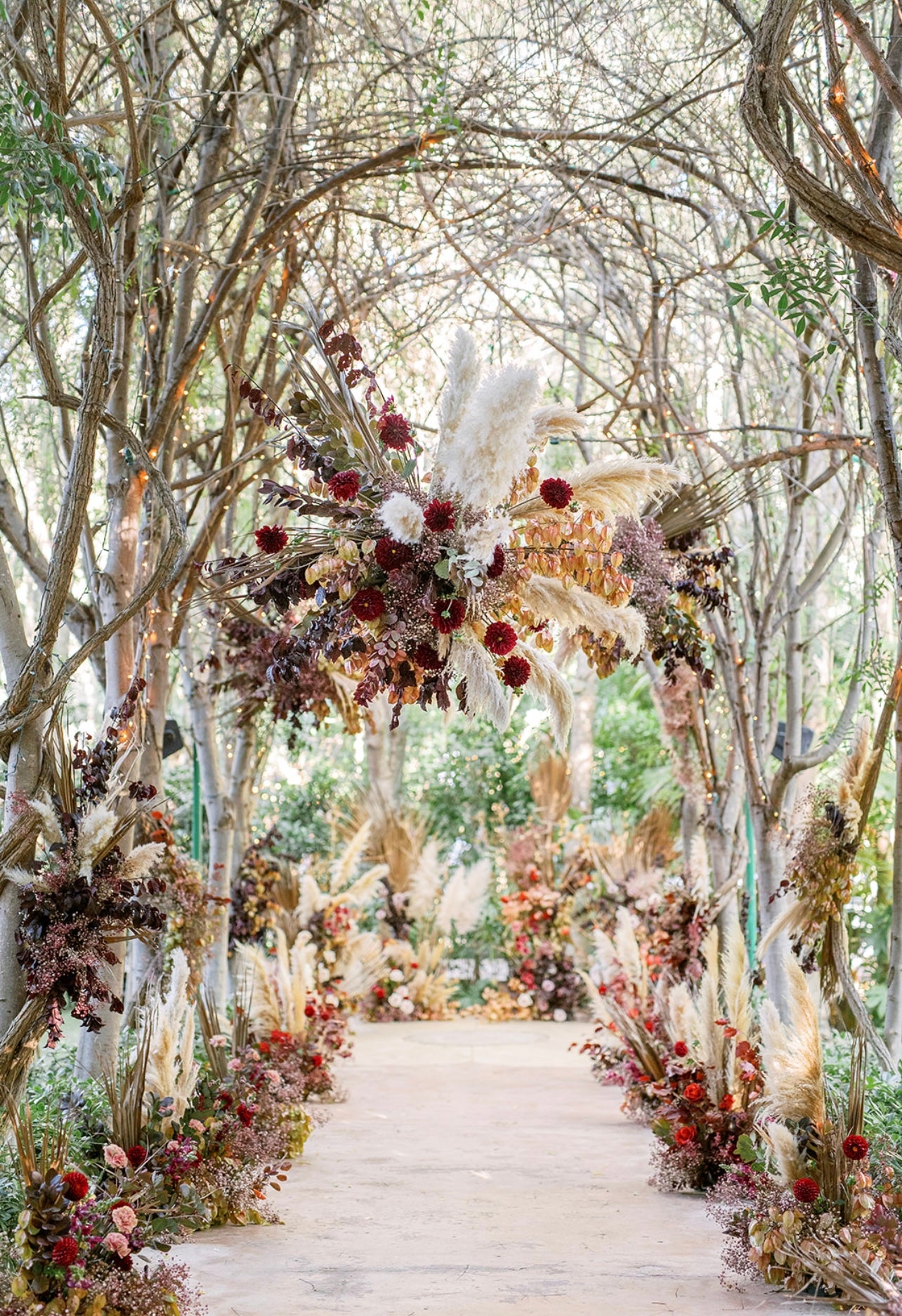 Dramatic autumnal hanging floral installation and aisle markers.