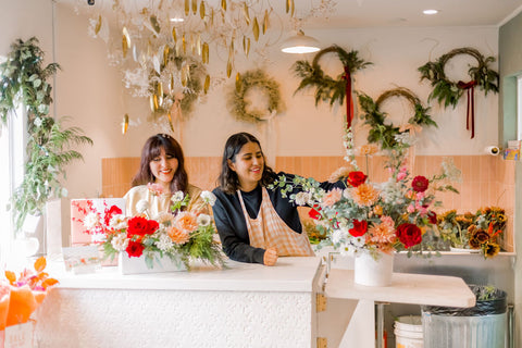Two florists arrange holiday flowers at Native Poppy in South Park