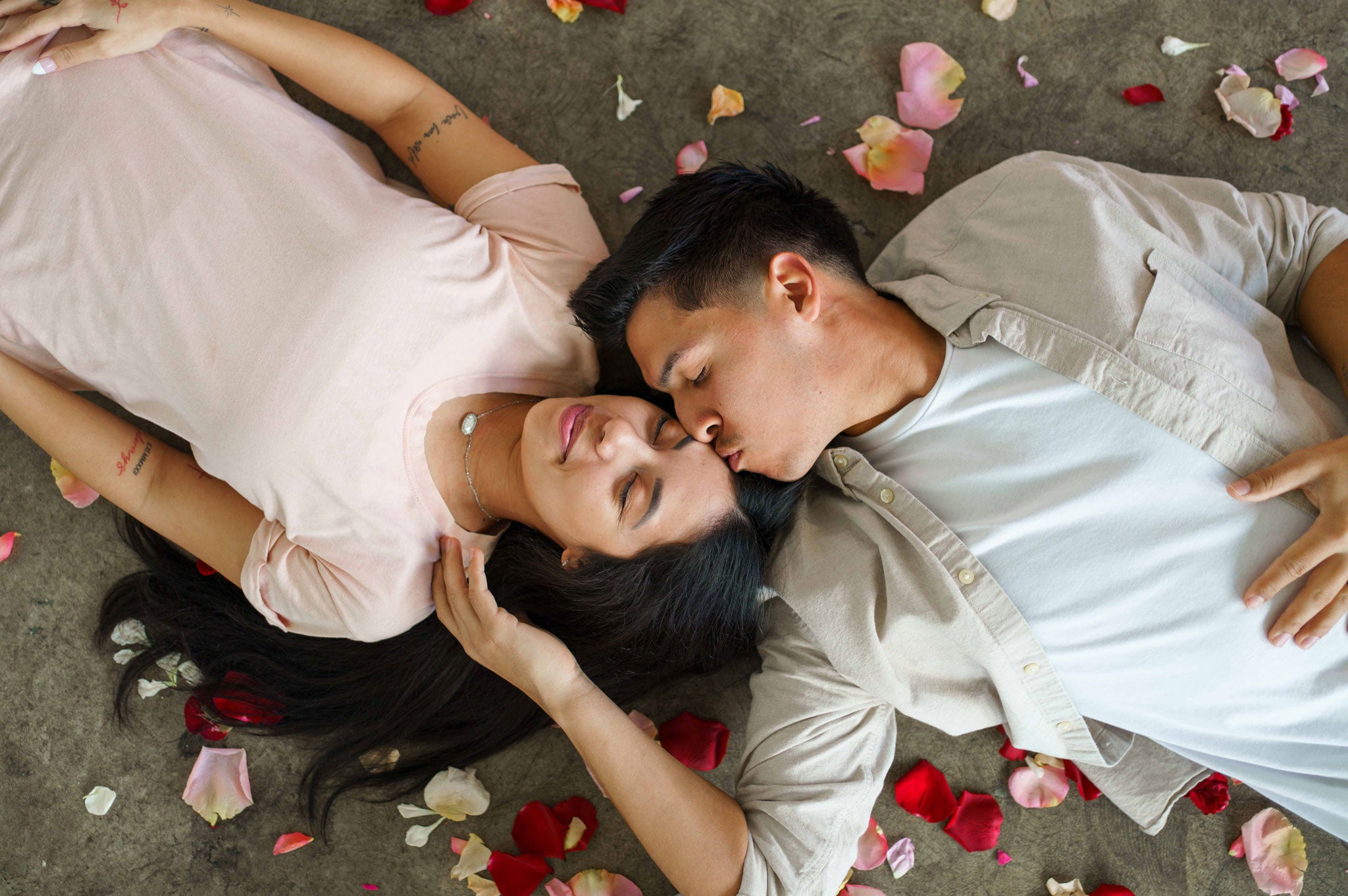 Couple laying in rose petals