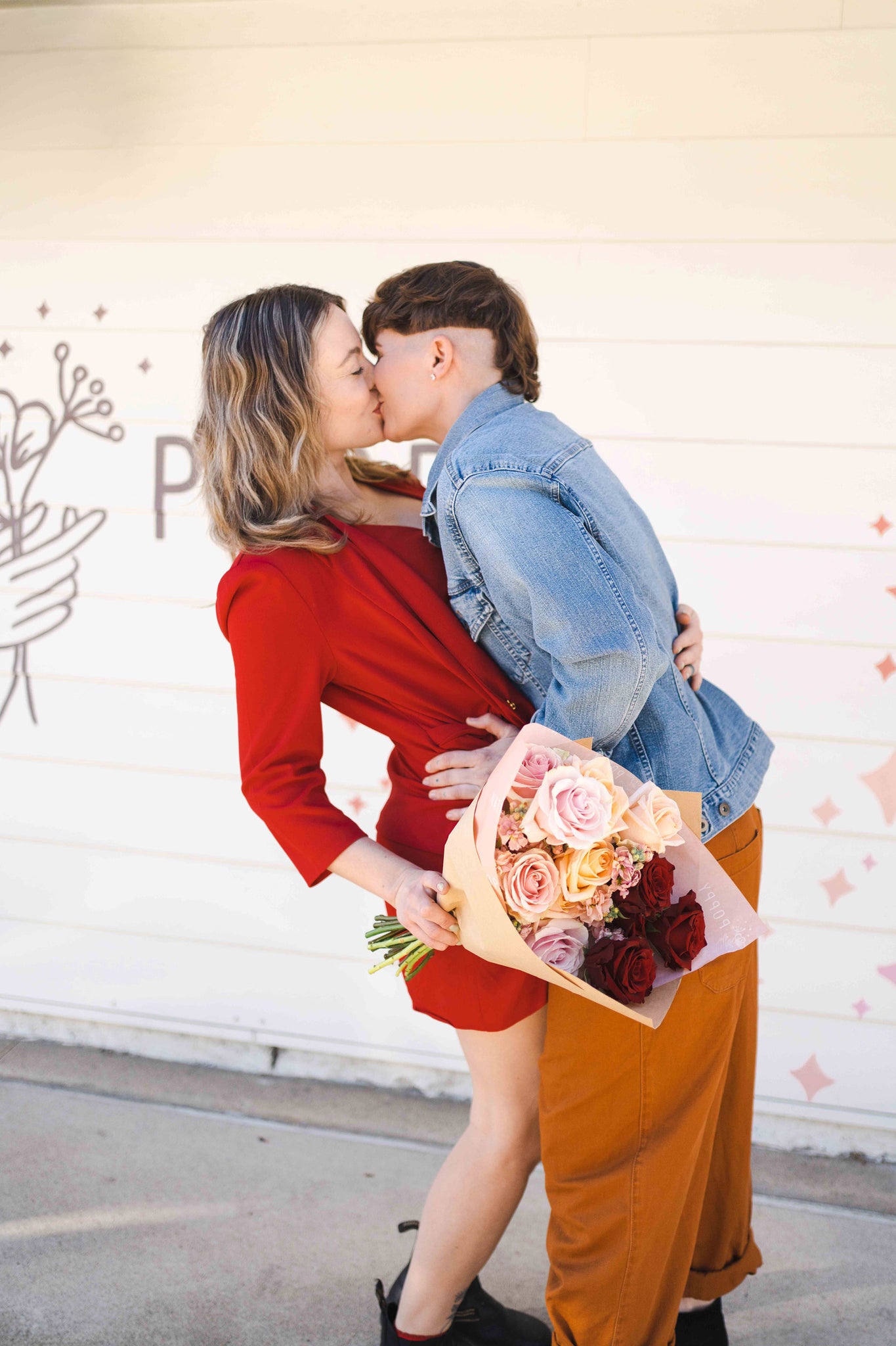 Couple standing with valentine arrangement kissing