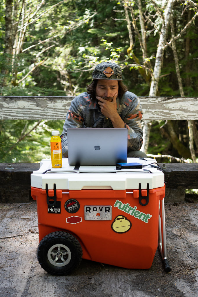 Man sets up his computer on top of his cooler