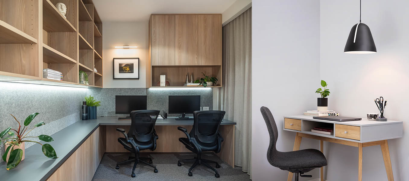 Home office with mid toned timber cabinets and under cabinet lighting, a small corner of a home office with black pendant lamp shining down on table.