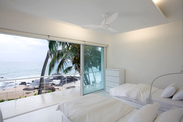 White Luna ceiling fan in bedroom with biew to beach