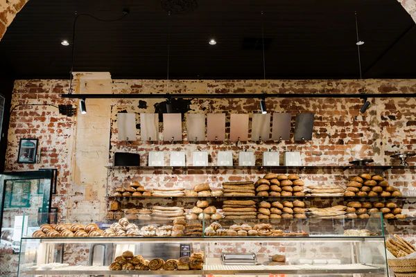 Vega track lighting and Signature downlights hanging above bread and pastry display in Ned's Bake local European cafe