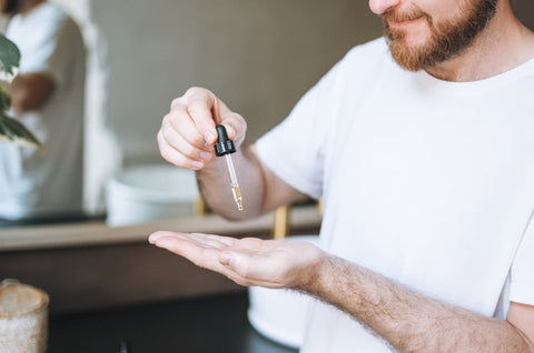 man putting beard oil in hand