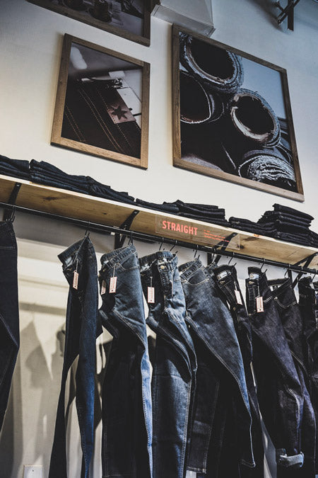 Jeans hanging with images of raw materials