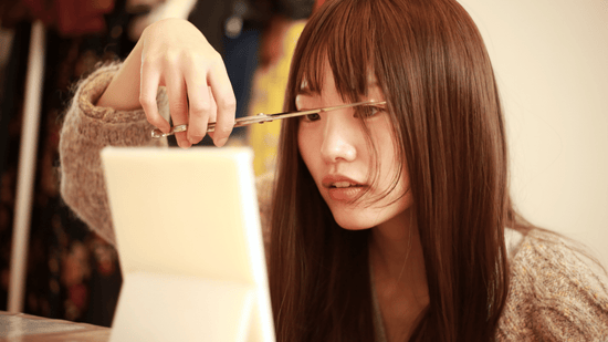 Woman getting her bangs styled with flat iron - The Perfect Bangs Flat Iron Guide