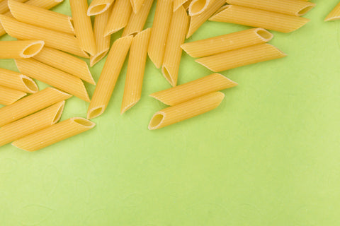 penne pasta against green background