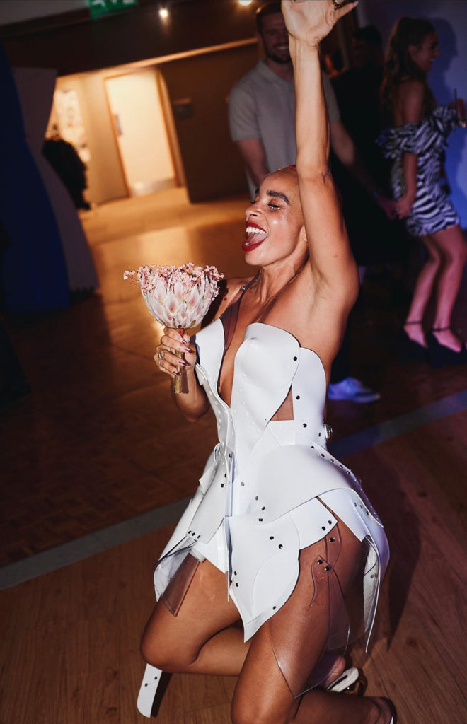 Sadie Clayton looked stunning wearing a Jivomir Domoustchiev white asymmetric vegan vinyl sculpture dress to her wedding party