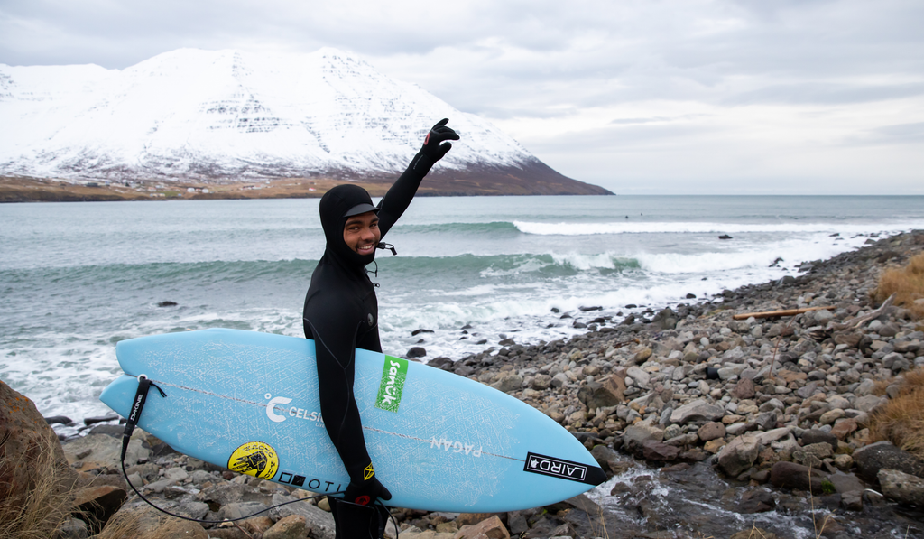 Hunter Jones standing holding his surfboard in Iceland