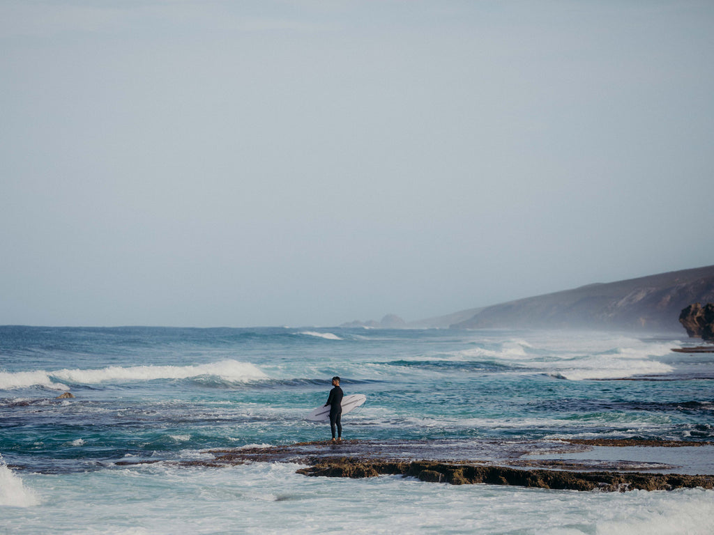 Jay Davies holding his surfboard