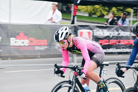 An image of Victoria, low over the handlebars of her bike, and riding quickly.