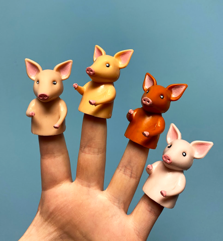 Four pig finger puppets in various colors
