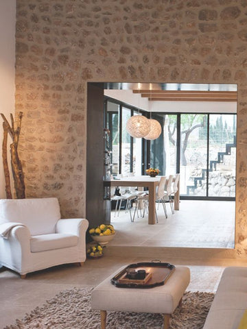 rustic stone wall with clean angular archway and glass doors beyond 