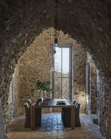 exposed stone arched ceiling with dining table beneath