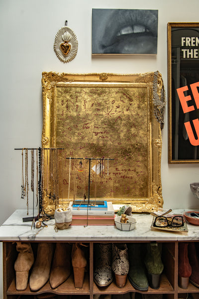 a vignette of Heather's antique cupboard turned shoe-rack, with various artworks, jewellery dishes and trinkets resting on top.