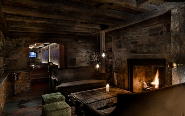 a cozy snug with open fire, stone walls and cozy furniture 