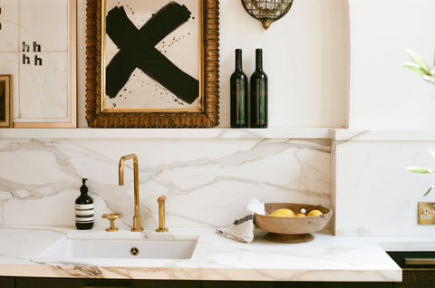 brass tap with marble splash back