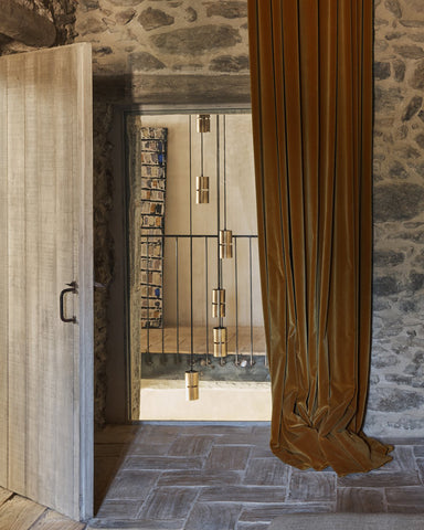 exposed stone wall with mustard velvet drape