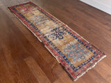 an antique heriz runner with a coral red border, mustard yellow / brown field and 4 medallions