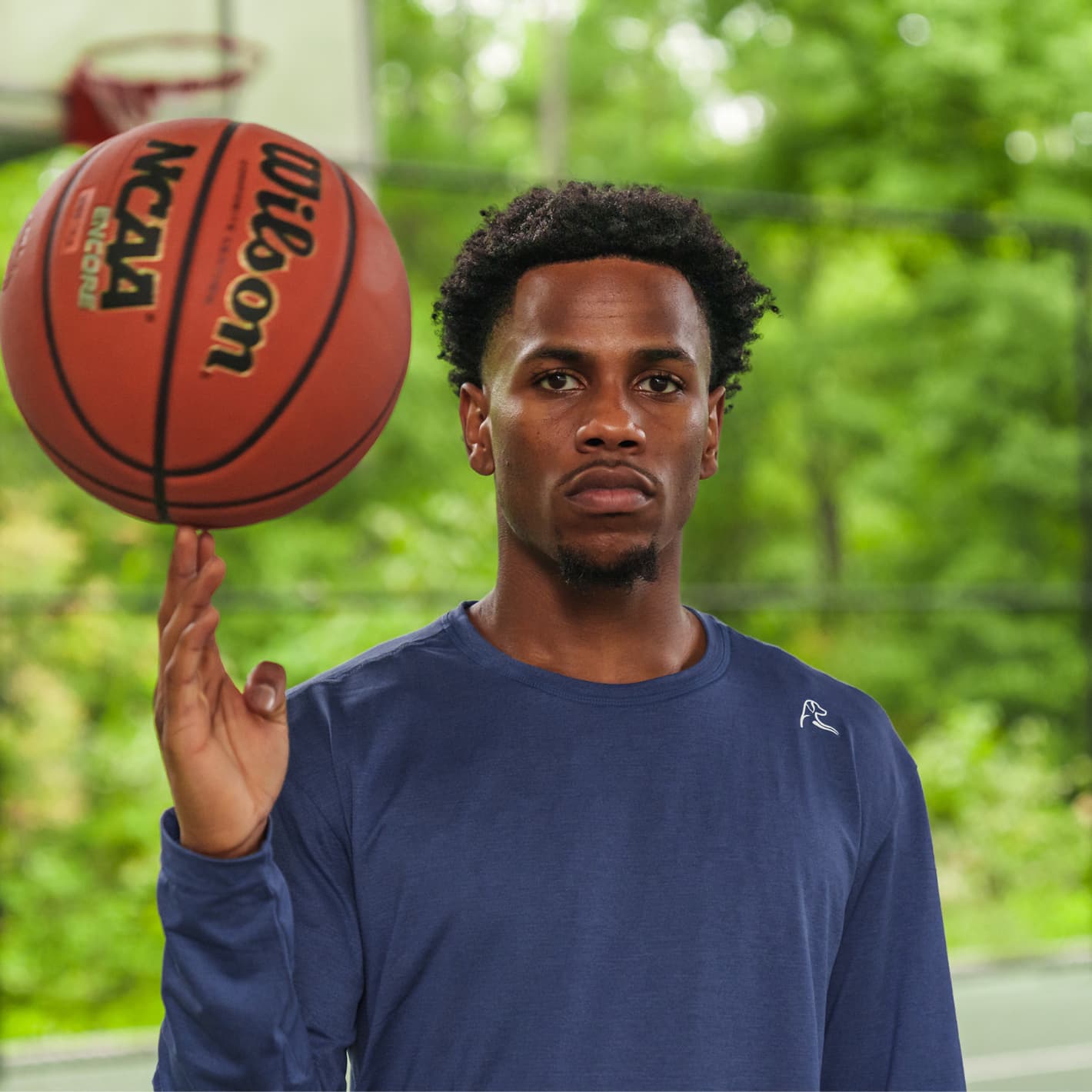 Jeremy Roach balancing a ball in his right hand wearing a Rhoback longsleeve tee