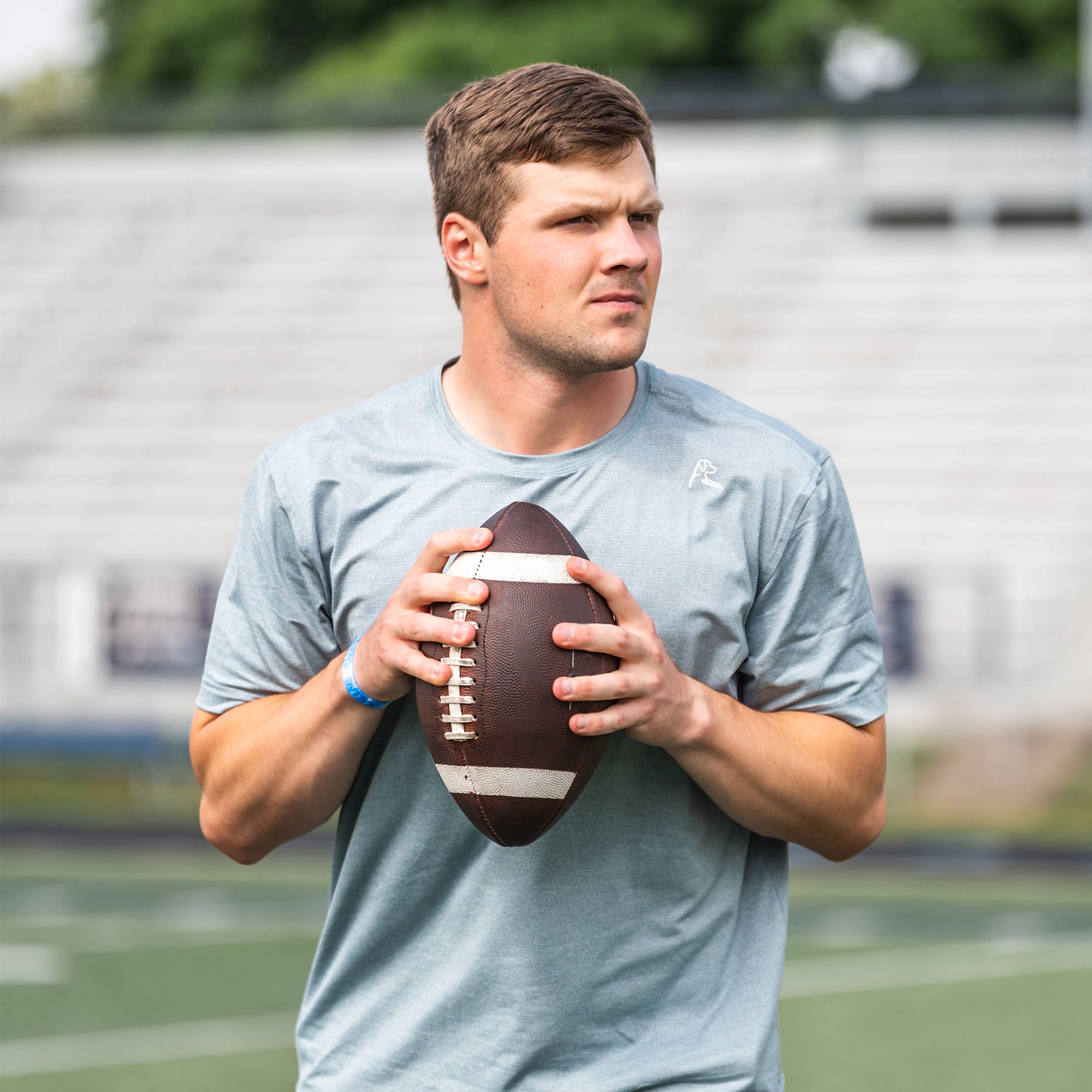 Kyle McCord holding a football and wearing The Stinger Tee