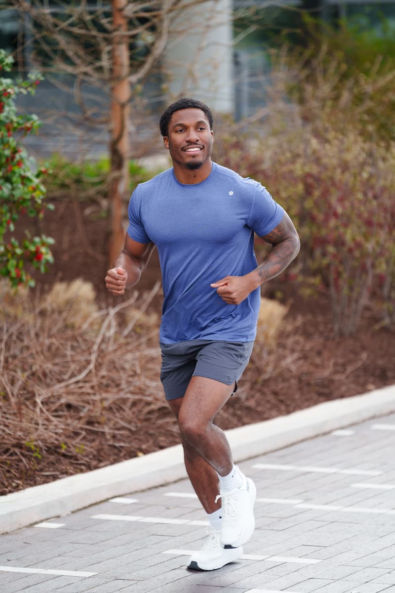 Man running outside wearing the Tailwind Performance Tee