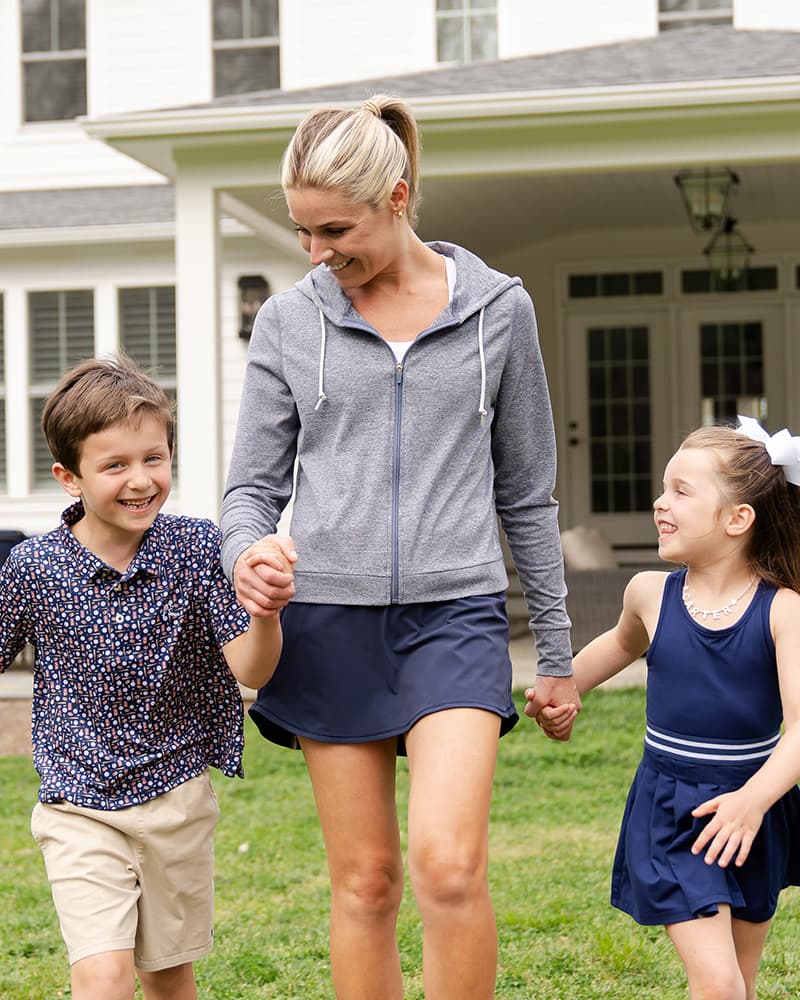 Mom with her 2 kids walking outside their house wearing Rhoback apparel.