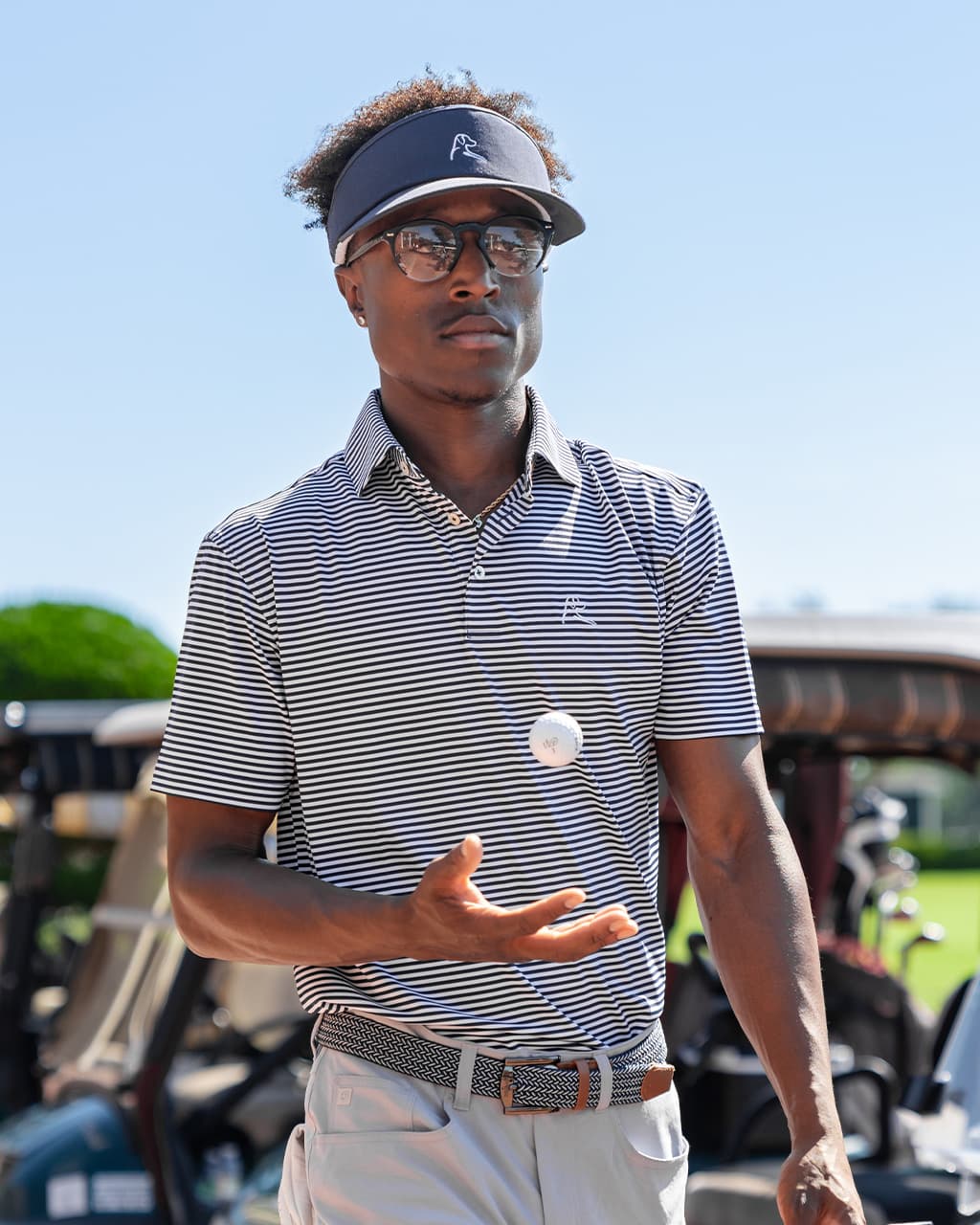 Man wearing a Rhoback Polo holding a golf ball.